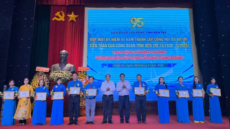 Trao kỷ niệm chương cho cán bộ công đoàn tại buổi họp mặt. (Ảnh: HOÀNG TRUNG)