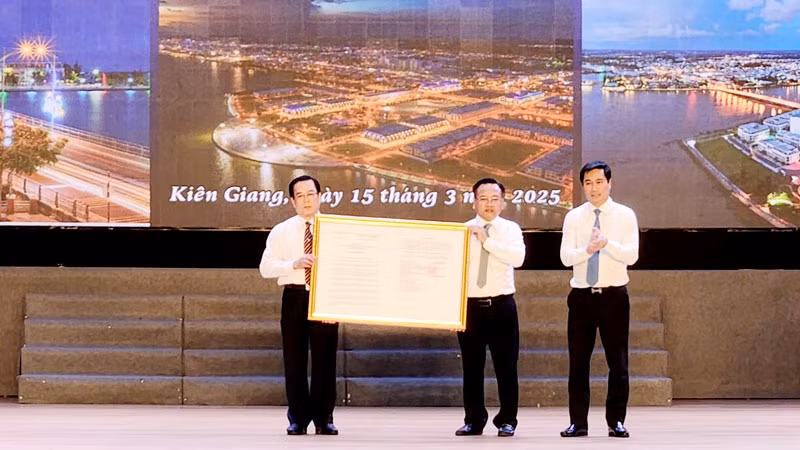 Lãnh đạo Bộ Xây dựng thừa ủy quyền trao Quyết định của Thủ tướng Chính phủ về việc công nhận thành phố Rạch Giá là đô thị loại I cho lãnh đạo thành phố Rạch Giá.