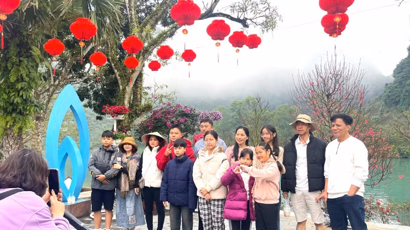 Du khách cùng nhau lưu lại bức ảnh đầu xuân bên dòng sông Son.