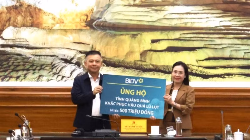 Đại diện Ngân hàng thương mại cổ phần Đầu tư và Phát triển Việt Nam trao 500 triệu đồng cho tỉnh Quảng Bình để hỗ trợ người dân vùng lũ.