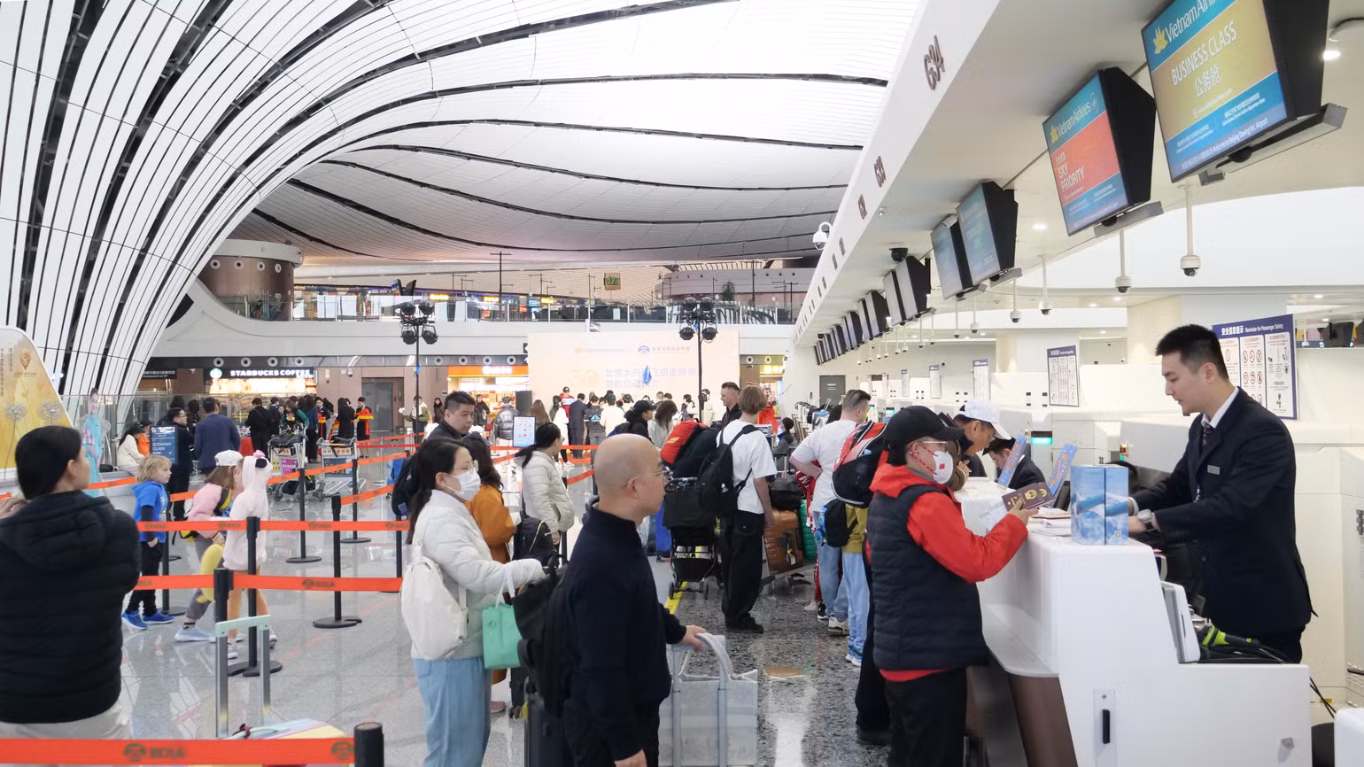 Hành khách làm thủ tục tại quầy của Vietnam Airlines tại sân bay quốc tế Đại Hưng, Bắc Kinh.