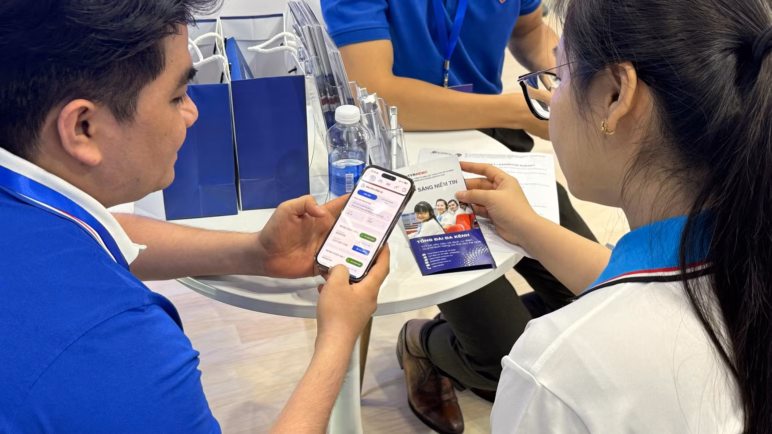 Nhân viên chăm sóc khách hàng ngành điện Thành phố Hồ Chí Minh hướng dẫn khách hàng thanh toán tiền điện trên điện thoại di động. Nhân viên chăm sóc khách hàng ngành điện Thành phố Hồ Chí Minh hướng dẫn khách hàng thanh toán tiền điện trên điện thoại di động.