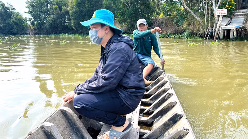 Người dân phải bơi xuồng qua để lấy xe máy gửi bên kia sông đi mua sắm.