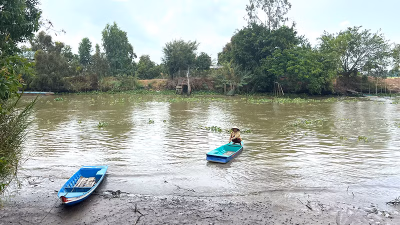 Không có đường, người dân phải bơi xuồng qua sông.