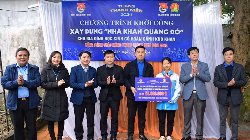 Các đại biểu trao tiền hỗ trợ xây dựng Nhà khăn quàng đỏ cho học sinh có hoàn cảnh khó khăn. Ảnh: NGỌC HÀ