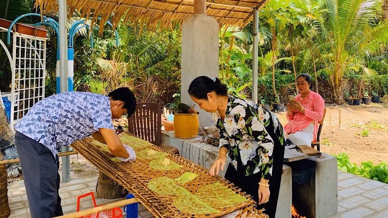 Du khách trải nghiệm làm bánh tráng tại điểm du lịch miệt vườn huyện Phong Điền.