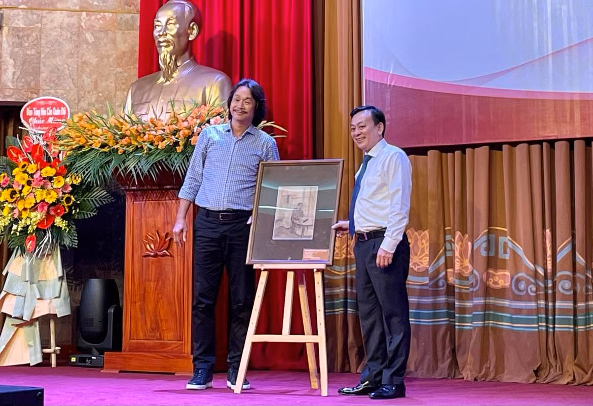 Tiếp nhận phác thảo "Bác Hồ viết Tuyên ngôn độc lập" của họa sĩ Văn Giáo do ông Nguyễn Văn Đức (bên trái) hiến tặng.