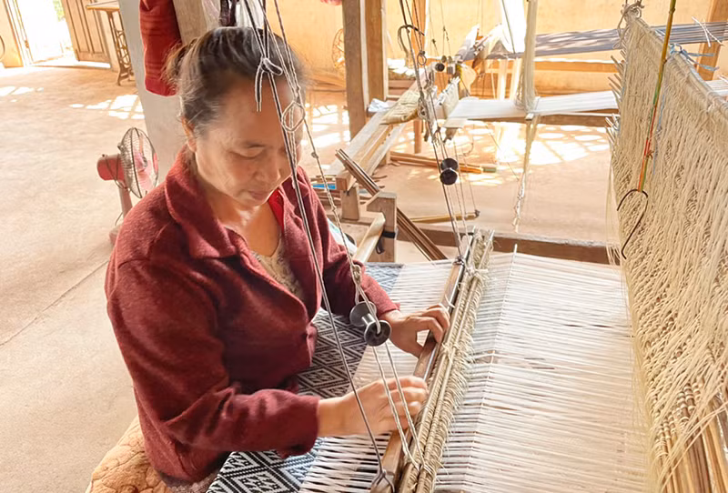 Một phụ nữ Lào đang dệt vải thủ công. (Ảnh: Hải Tiến) Một phụ nữ Lào đang dệt vải thủ công. (Ảnh: Hải Tiến)