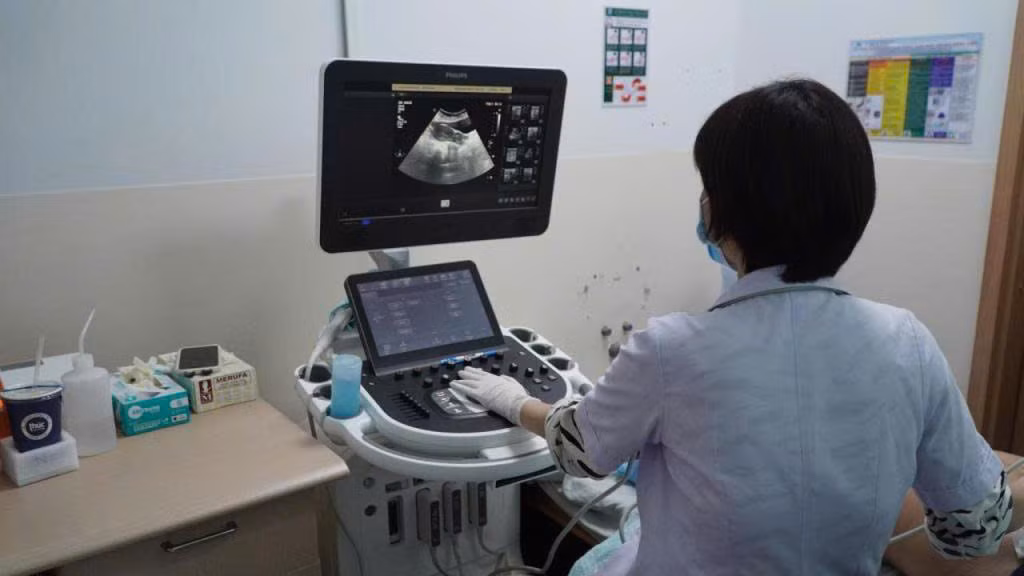 Các bác sĩ tiến hành siêu âm cho người thăm khám Các bác sĩ tiến hành siêu âm cho người thăm khám