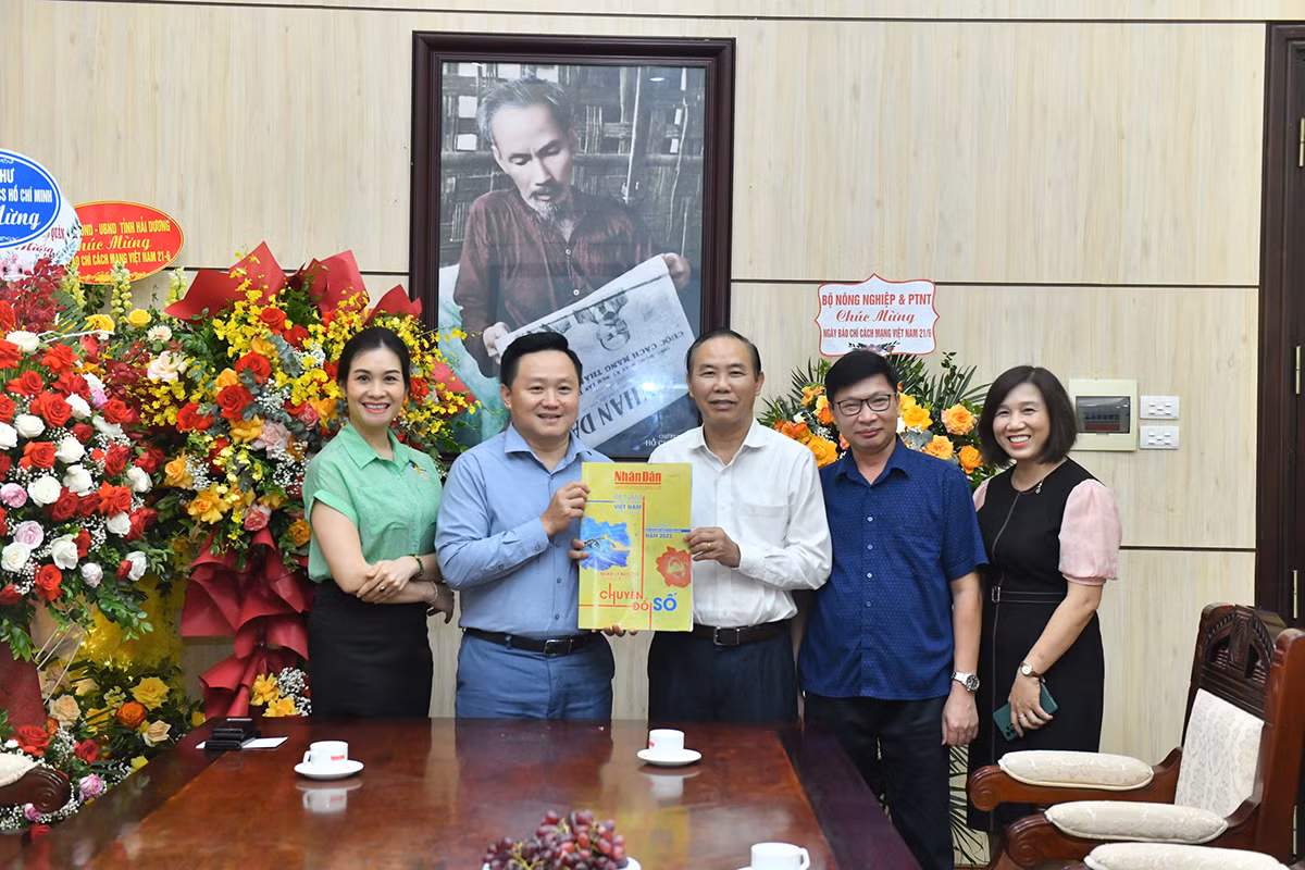 Phó Tổng Biên tập Báo Nhân Dân Phan Văn Hùng tặng Thứ trưởng Nông nghiệp và Phát triển nông thôn Phùng Đức Tiến số báo đặc biệt kỷ niệm 98 năm Ngày Báo chí cách mạng Việt Nam. (Ảnh: Đăng Khoa)