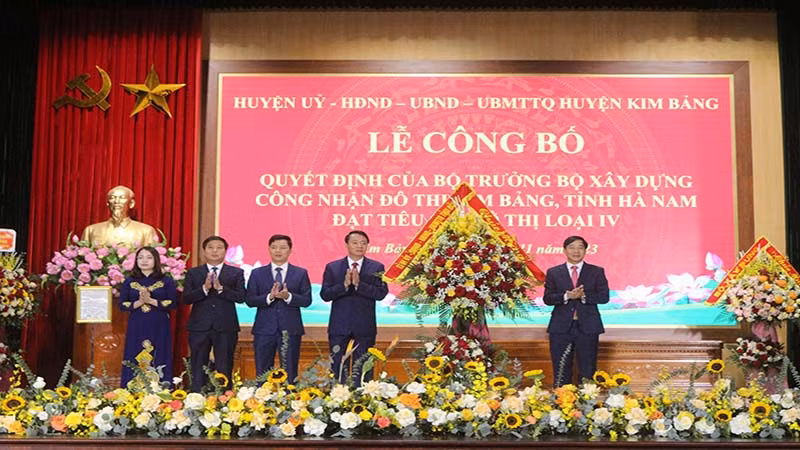 Đồng chí Nguyễn Anh Chức, Phó Chủ tịch Ủy ban nhân dân tỉnh tặng hoa chúc mừng Đảng bộ, chính quyền và nhân dân huyện Kim Bảng.