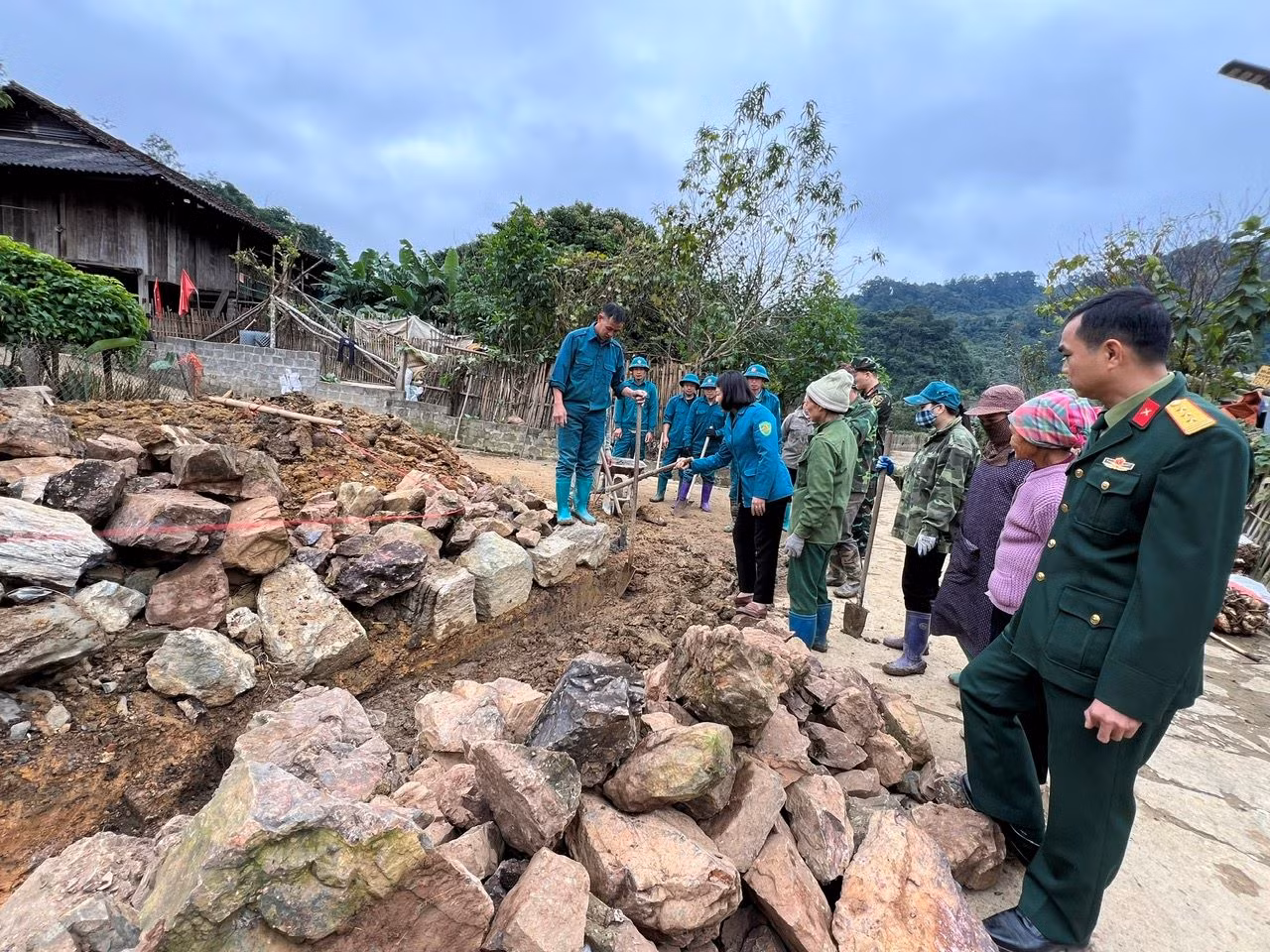 Lãnh đạo huyện Bạch Thông hướng dẫn người dân cách thức xếp đá xây dựng hàng rào.