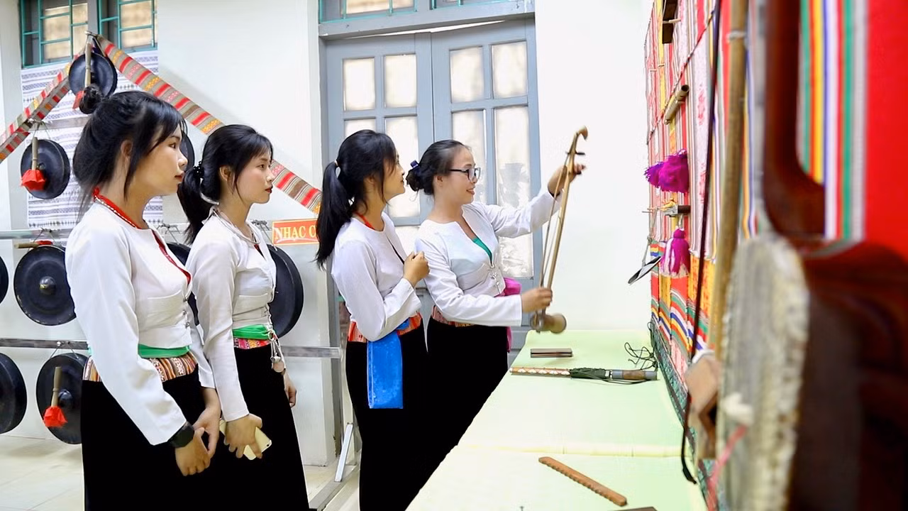 Cô giáo Trịnh Thị Hào (đứng trong cùng) -Trường THPT Quyết thắng hướng dẫn các em trongCLB tìm hiểu về nhạc cụ dân tộc Mường.