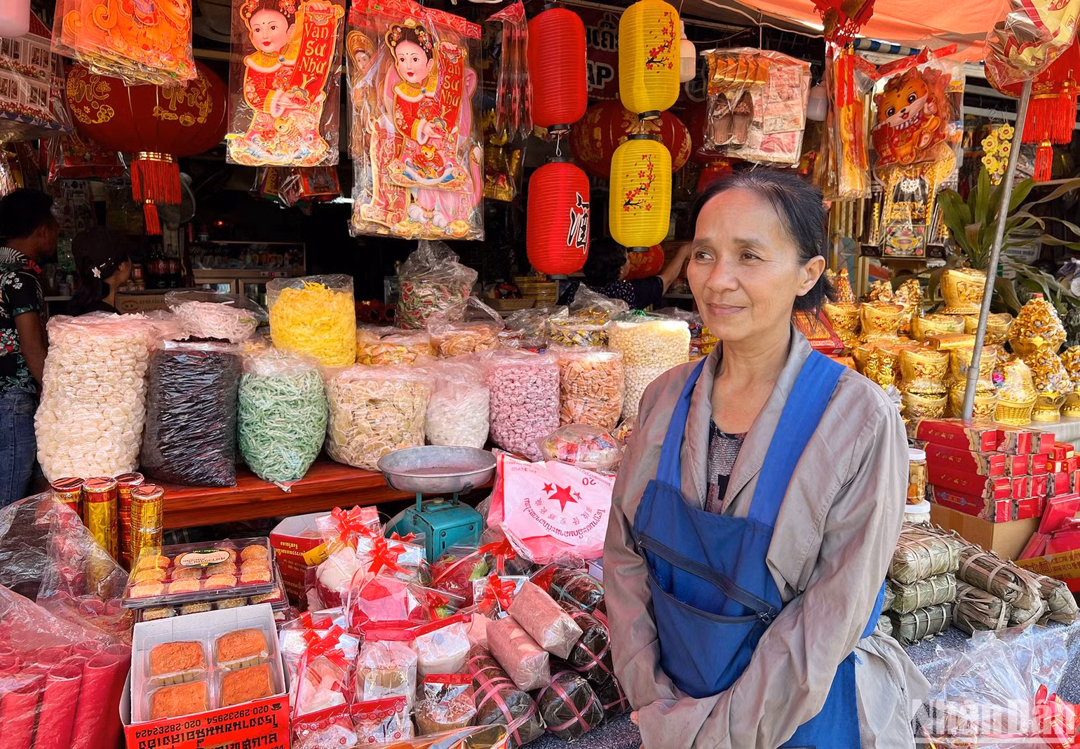 Chị Bé Chòi bên quầy kinh doanh của gia đình bán bánh, mứt, kẹo và lịch Việt Nam. (Ảnh: TRỊNH DŨNG) Chị Bé Chòi bên quầy kinh doanh của gia đình bán bánh, mứt, kẹo và lịch Việt Nam. (Ảnh: TRỊNH DŨNG)