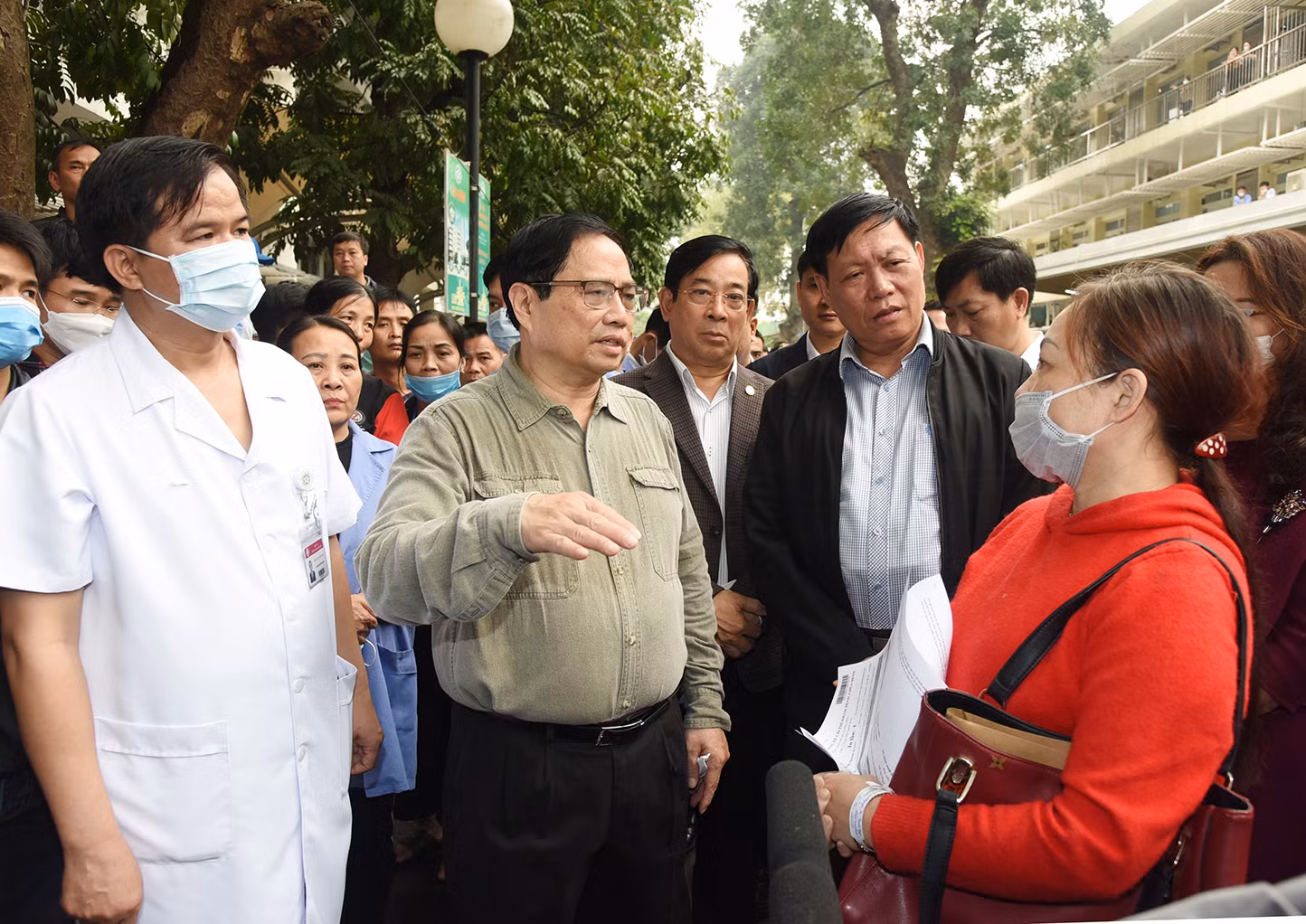 Thủ tướng trò chuyện với người nhà bệnh nhân về tình hình đáp ứng vật tư y tế và thuốc men tại Bệnh viện Bạch Mai.