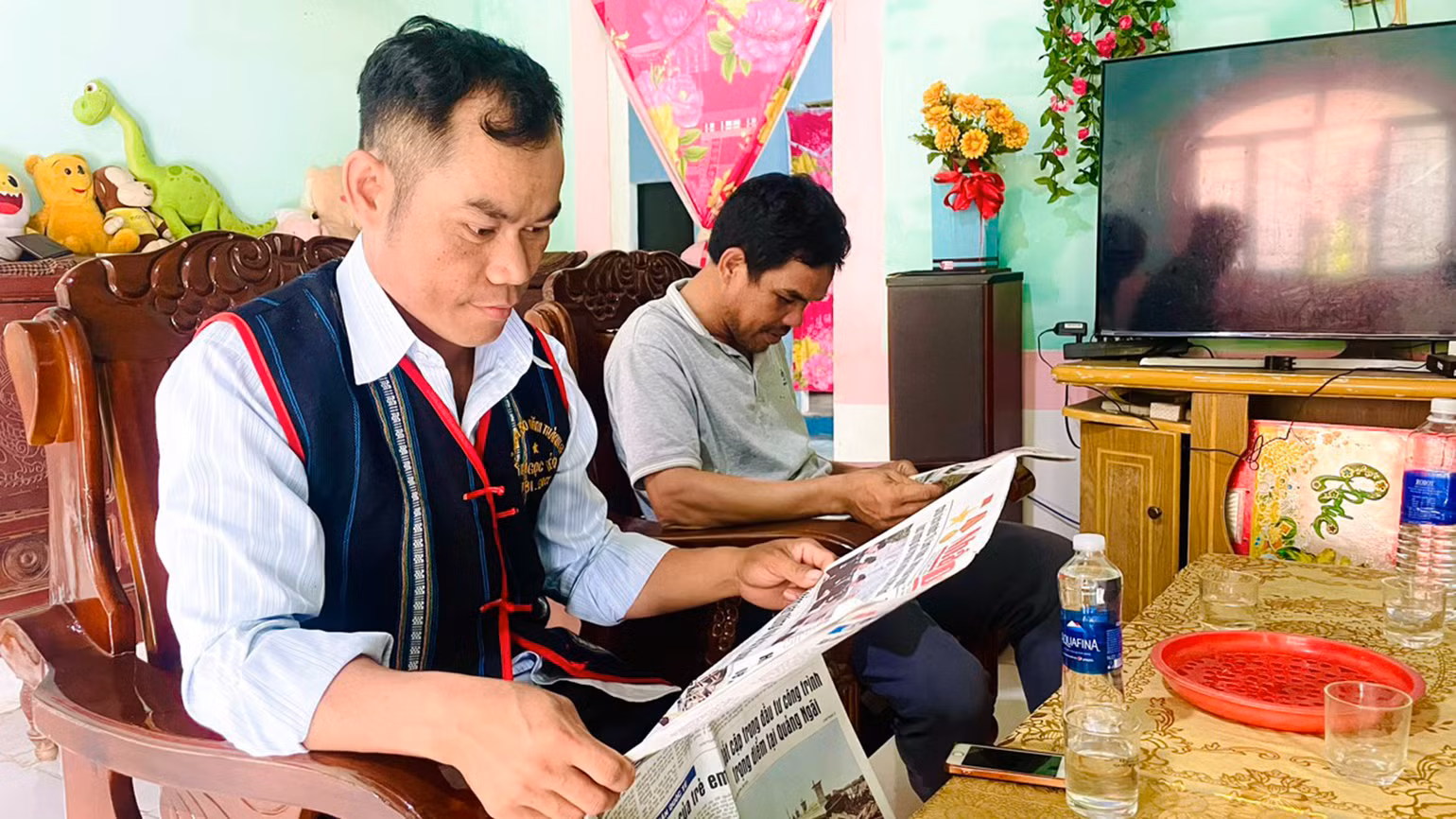 Đồng chí A Thảo (trái) thường xuyên đọc và làm theo báo Đảng để thực hiện hiệu quả công tác tuyên truyền.