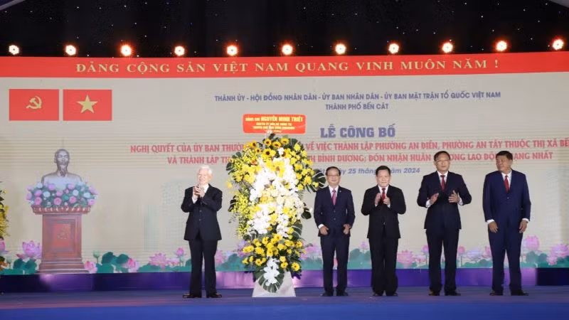 Nguyên Chủ tịch nước Nguyễn Minh Triết trao tặng hoa chúc mừng thành phố Bến Cát.