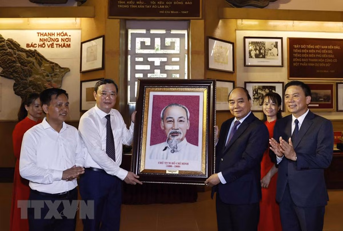 Chủ tịch nước Nguyễn Xuân Phúc tặng bức ảnh chân dung Chủ tịch Hồ Chí Minh cho Ban Quản lý Khu văn hóa tưởng niệm Bác Hồ. (Ảnh: Thống Nhất/TTXVN)