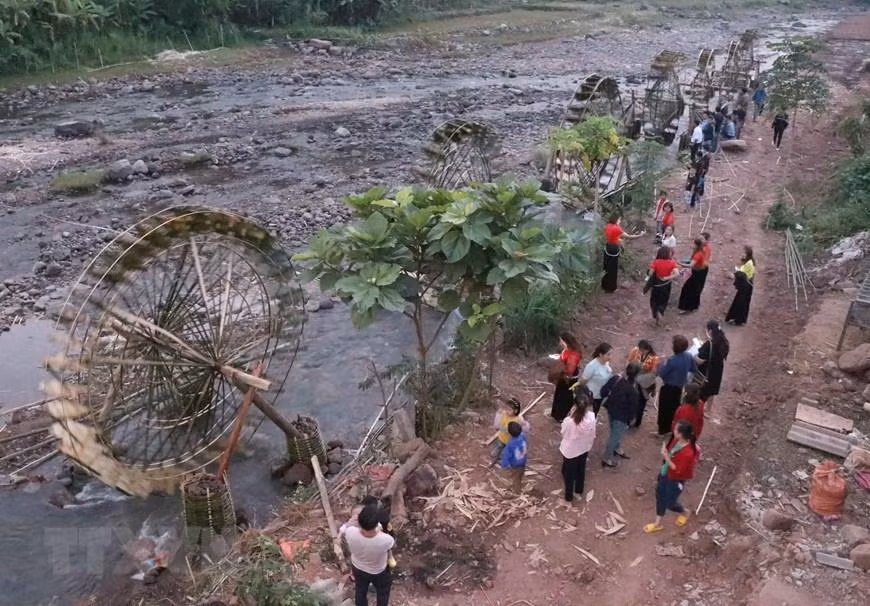 Du khách tham quan hệ thống những cọn nước trên suốt chiều dài hàng chục mét bên suối Nậm Bai chảy quanh bản Nà Sự. (Ảnh: Xuân Tiến/TTXVN)