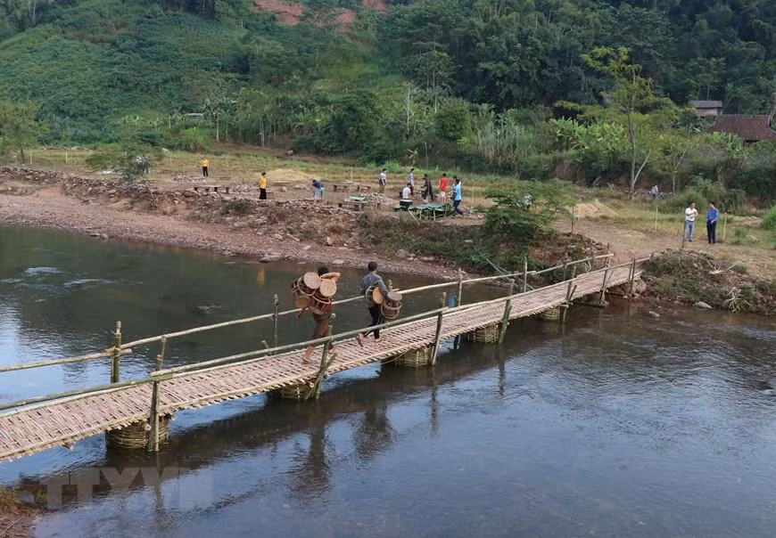 Cây cầu tre bắc qua suối Nậm Bai là con đường dẫn sang bãi đất trống, nơi diễn ra các chương trình giao lưu văn hóa, văn nghệ và thưởng thức ẩm thực ngoài trời khi du khách đến bản Nà Sự. (Ảnh: Xuân Tiến/TTXVN)