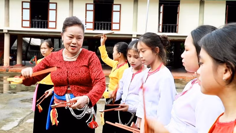 Bà Dung đang dạy những làn điệu dân ca Mường cho các cháu tại Nhà Văn hóa thị trấn Bo, huyện Kim Bôi.