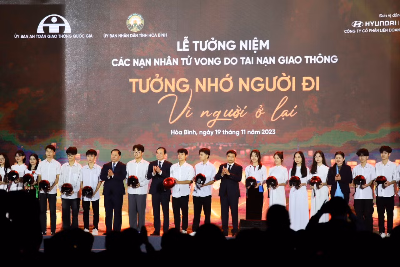 Phó Thủ tướng Trần Lưu Quang cùng Bộ trưởng Giao thông Vận tải Nguyễn Văn Thắng, Bí thư Tỉnh ủy Hòa Bình Nguyễn Phi Long trao tặng mũ bảo hiểm cho các em học sinh tại buổi Lễ tưởng niệm.