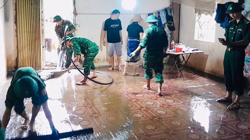 Bộ đội Biên phòng trợ giúp hộ dân dọn bùn đất tràn vào nhà.