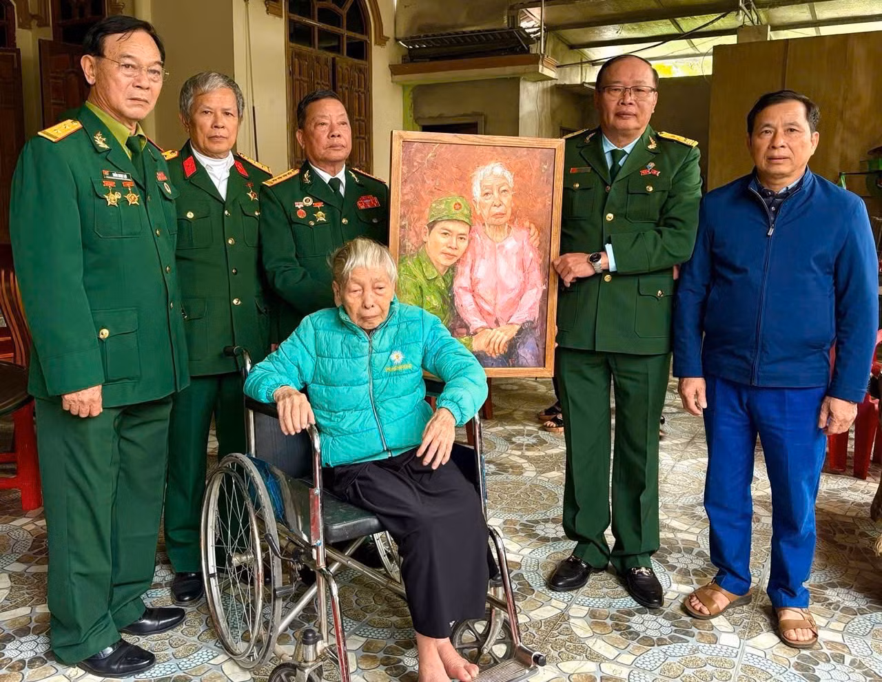 Đại tá Nguyễn Đức Cam - nguyên Phó Sư đoàn trưởng - Tham mưu trưởng Sư đoàn 356 (đứng thứ 3 bên trái) và các đồng đội của liệt sĩ Nguyễn Đình Long, trao tặng Mẹ Việt Nam Anh Hùng Thái Thị Yêm bức tranh “Long về với Mẹ”.
