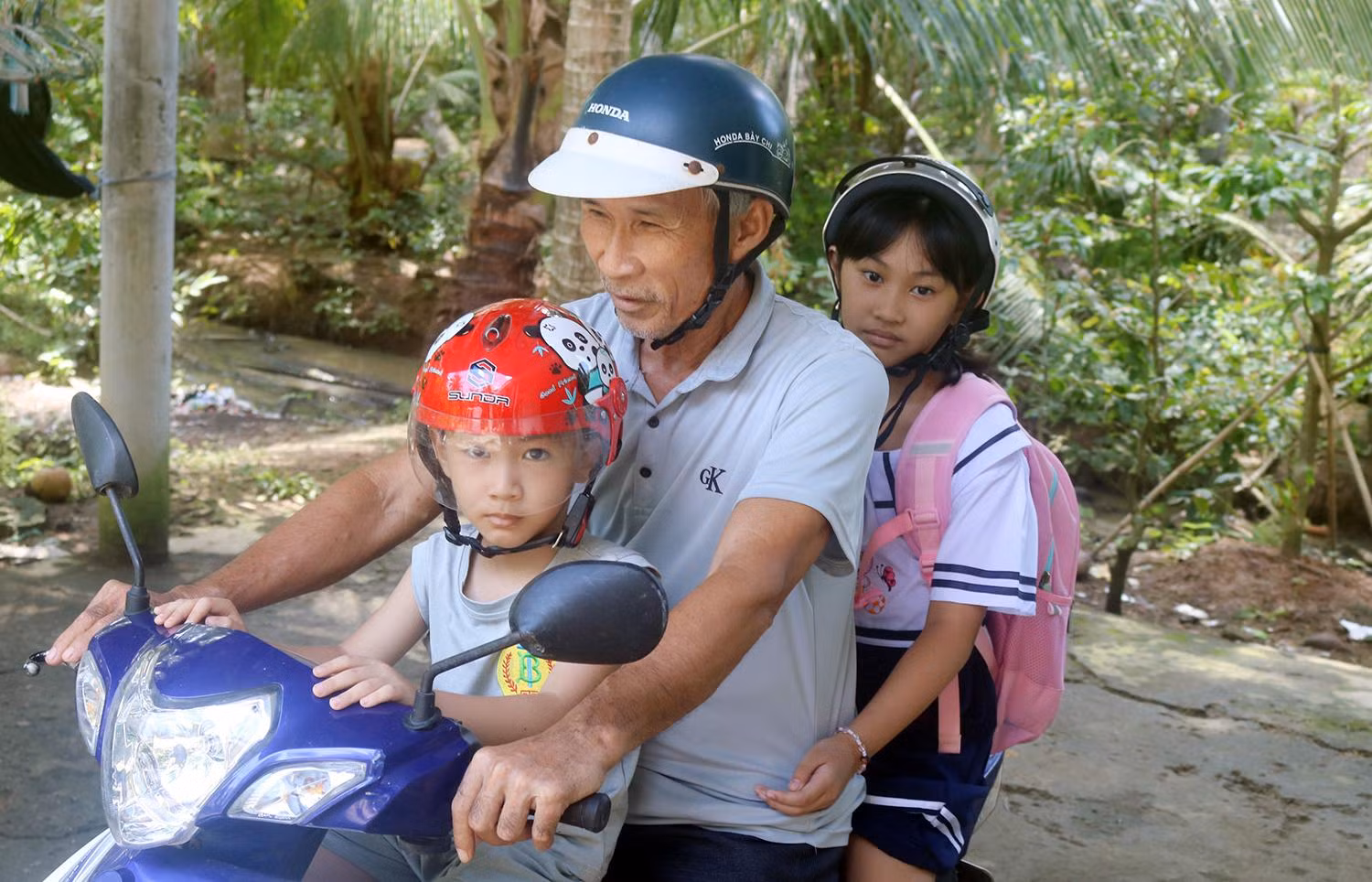 Ông Nguyễn Văn Tấn, ấp Định Bình, xã Long Thới, huyện Tiểu Cần, tỉnh Trà Vinh đưa các cháu ngoại đến trường. Ông Nguyễn Văn Tấn, ấp Định Bình, xã Long Thới, huyện Tiểu Cần, tỉnh Trà Vinh đưa các cháu ngoại đến trường.