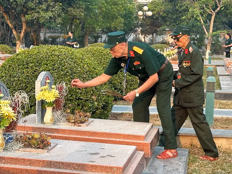 Những người lính năm xưa thắp hương viếng đồng đội.