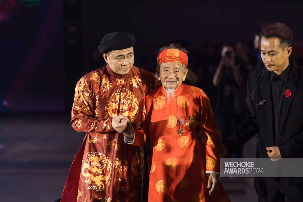 NSND Tự Long đỡ nhà nghiên cứu Nguyễn Đình Tư lên nhận giải thưởng. (Ảnh: We Choice Award)