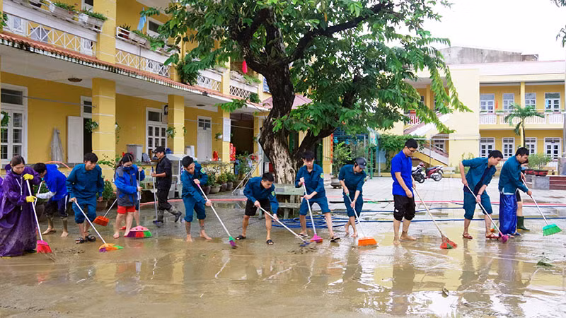Lực lượng dân quân giúp Trường tiểu học số 1 Hương Vinh (TP Huế) dọn dẹp vệ sinh sân trường.