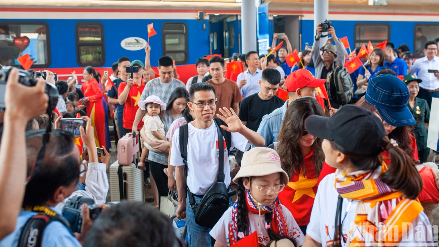 Những hành khách trên hai đoàn tàu Thống Nhất hân hoan đi vào nhà ga.