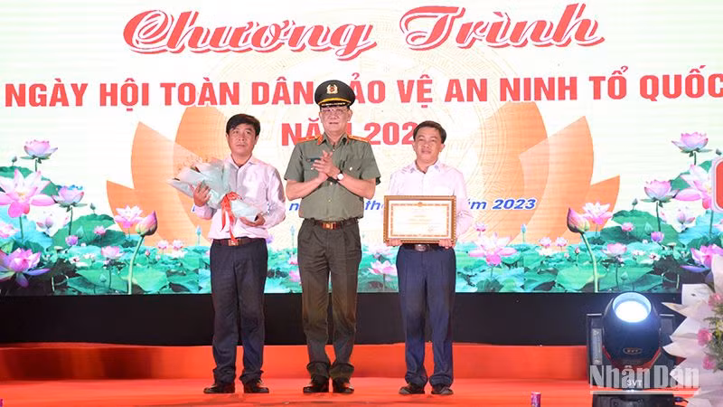 Đại diện Bộ Công an trao tặng Bằng khen cho nhân dân và cán bộ xã Hàm Liêm, huyện Hàm Thuận Bắc đã có thành tích xuất sắc trong phong trào Toàn dân bảo vệ an ninh Tổ quốc. (Ảnh: Đình Châu)