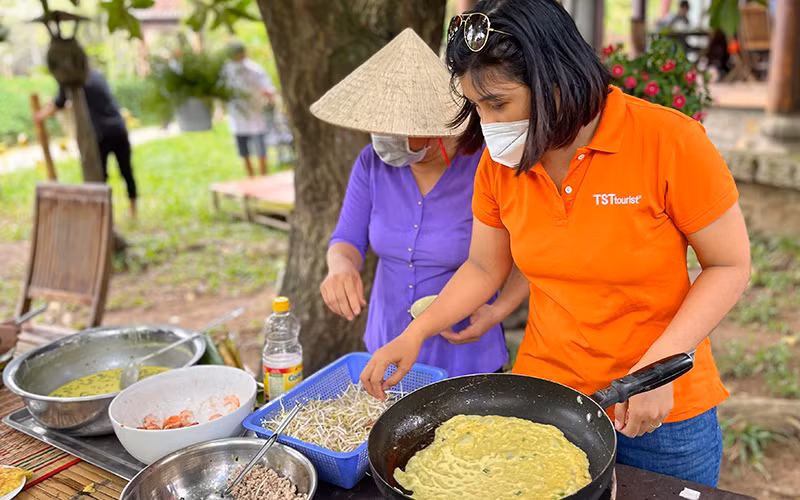 Du khách trải nghiệm làm bánh xèo tại Bảo tàng Áo dài trong tua "Thủ Ðức - Thành phố bên dòng sông xanh".