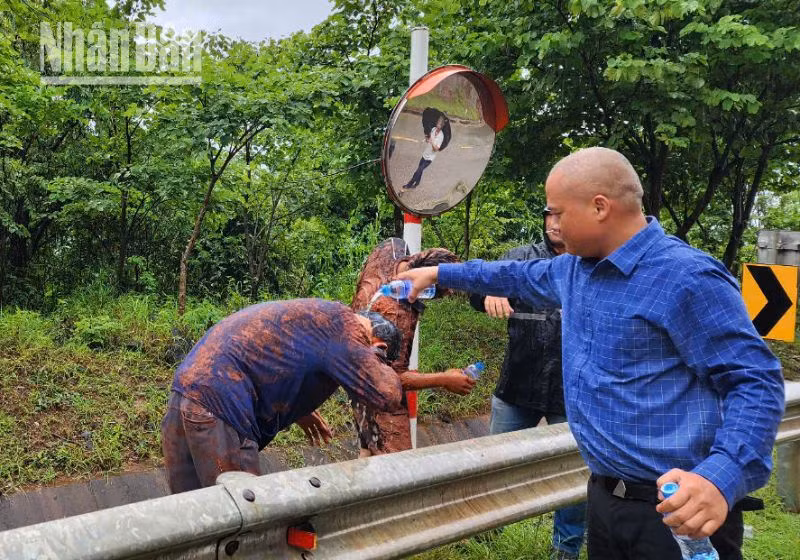 Người dân hỗ trợ, giúp những người trên 2 xe ô-tô bị sạt đất đá từ phía ta-luy dương trên tuyến quốc lộ 6. (Ảnh: NHẬT MINH)