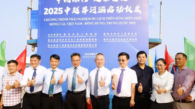 Đại biểu hai chính quyền và các doanh nghiệp chào mừng sự kiện khởi động Chương trình trải nghiệm du lịch trên sông biên giới.