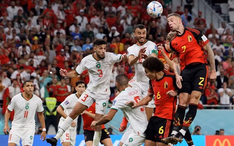 Pha tranh bóng giữa đội Maroc (áo sáng) và Bỉ. Pha tranh bóng giữa đội Maroc (áo sáng) và Bỉ.