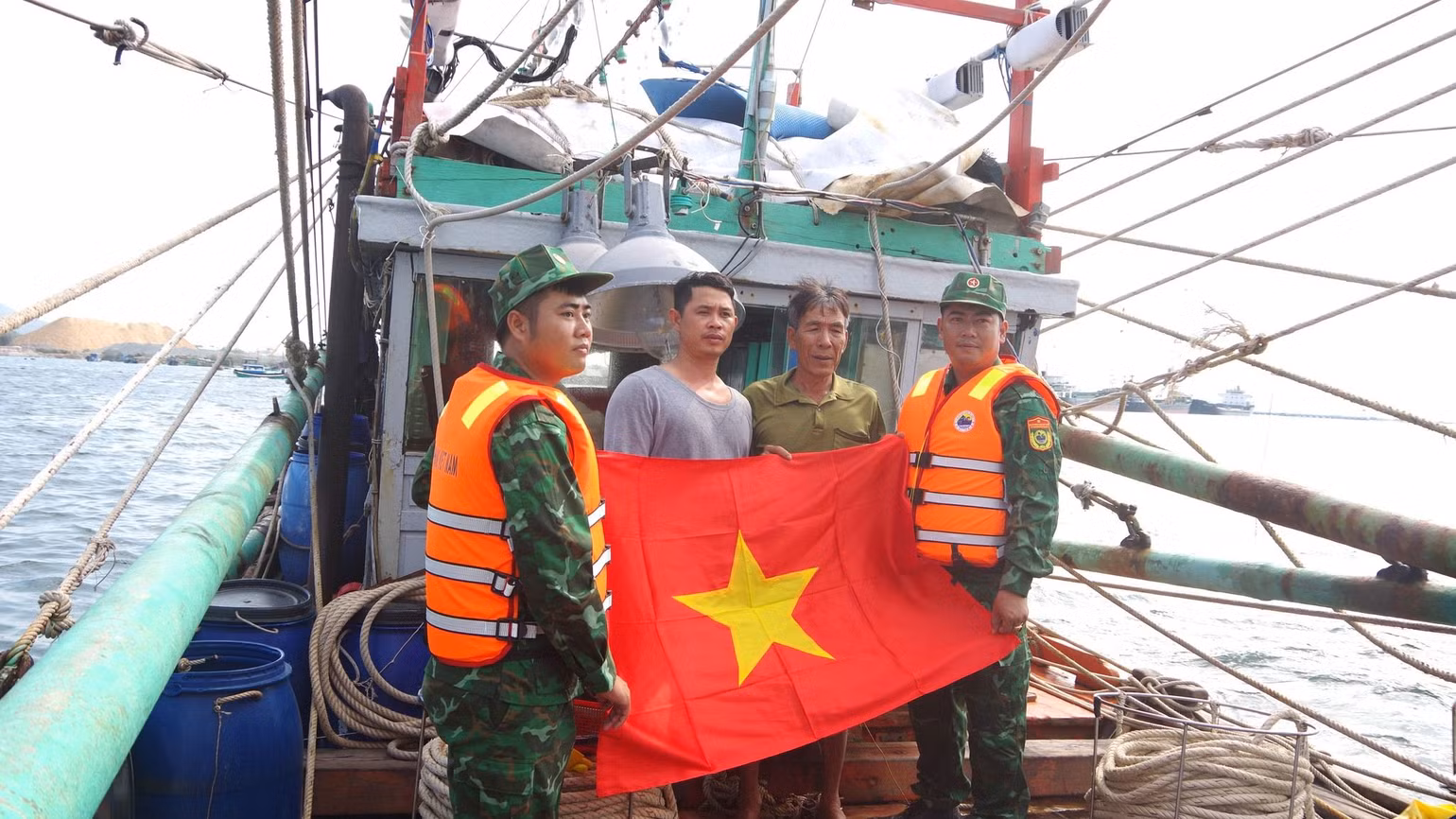 Cán bộ, chiến sĩ Đồn Biên phòng Cam Ranh tặng cờ cho ngư dân bám biển. (Ảnh: Bộ đội biên phòng tỉnh Khánh Hòa)