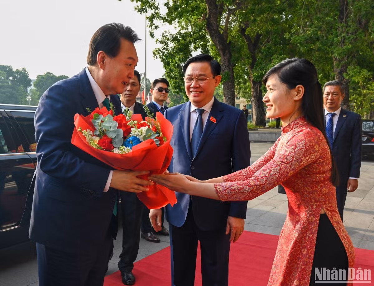Lễ tân Văn phòng Quốc hội tặng hoa chào mừng Tổng thống Hàn Quốc Yoon Suk Yeol.