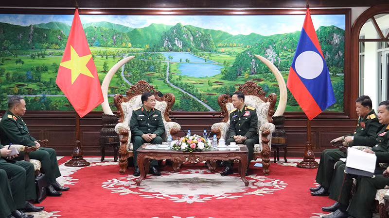 Thượng tướng Hoàng Xuân Chiến trao đổi với Bộ trưởng Quốc phòng Lào. (Ảnh: TRỊNH DŨNG)