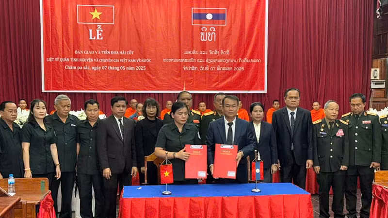 Đại diện tỉnh Kon Tum và tỉnh Champasak ký biên bản bàn giao và tiễn đưa 16 hài cốt liệt sĩ về nước. (Ảnh: Hải Tiến)