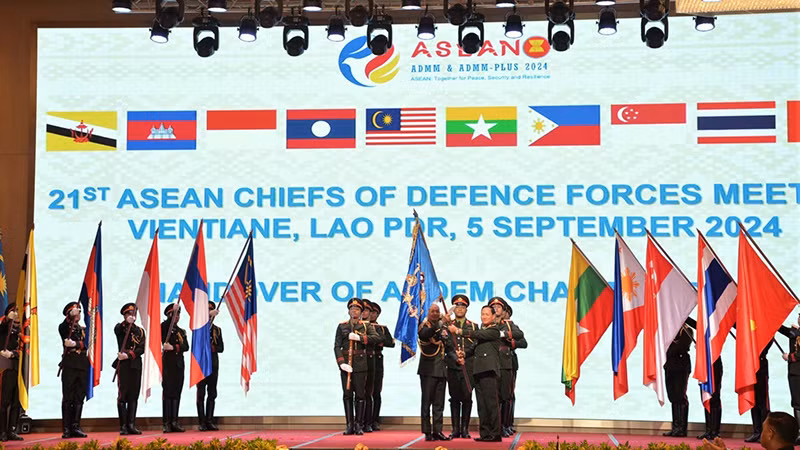 Tổng Tham mưu trưởng Quân đội nhân dân Lào trao cờ đăng cai cho đại diện Malaysia. (Ảnh: Hải Tiến)