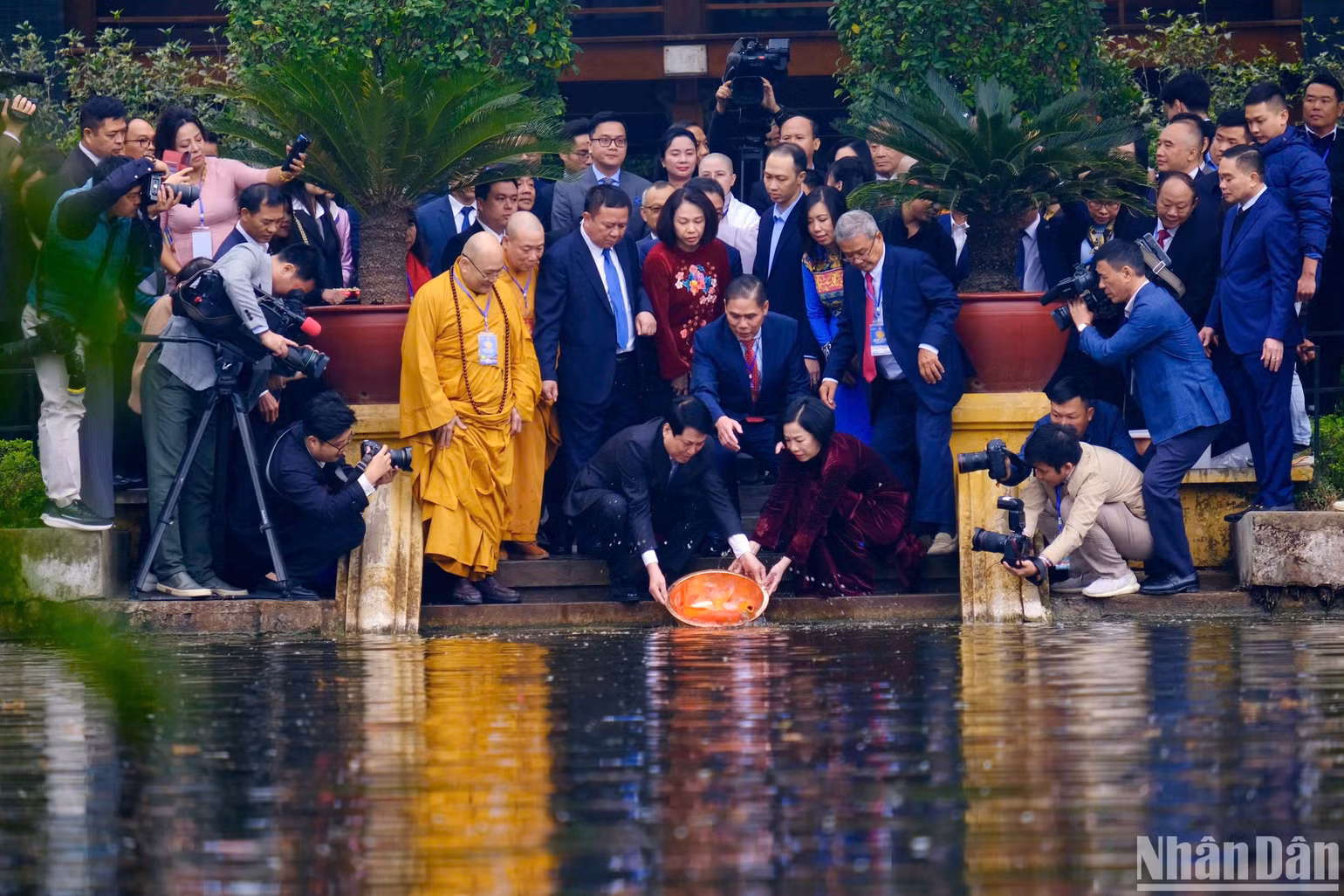 Chủ tịch nước và Phu nhân thực hiện nghi thức thả cá chép tại Ao cá Bác Hồ.