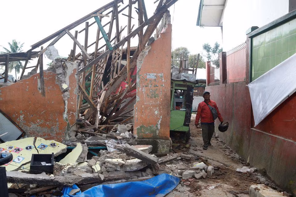 Người đàn ông đi qua nhà trẻ bị sập tại làng Cugenang. (Ảnh: Reuters) Người đàn ông đi qua nhà trẻ bị sập tại làng Cugenang. (Ảnh: Reuters)