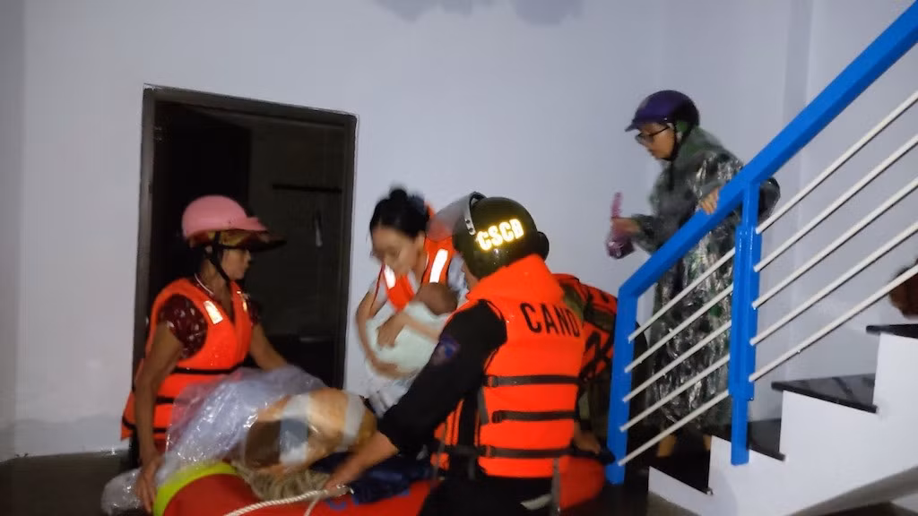 Nhiều trẻ em tiếp tục được di tản đến nơi tránh trú lũ an toàn.