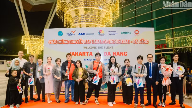 Đại diện Sở Du lịch thành phố Đà Nẵng và các đơn vị liên quan tặng quà cảm ơn những du khách đầu tiên từ Jakarta đến Đà Nẵng. (Ảnh: ANH ĐÀO)