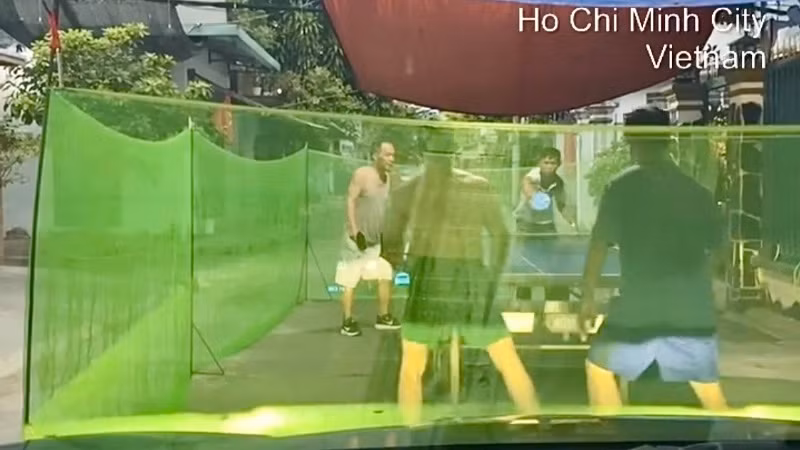 Nhóm 4 người đàn ông vây lưới đánh bóng bàn giữa đường. (Ảnh cắt từ video clip) Nhóm 4 người đàn ông vây lưới đánh bóng bàn giữa đường. (Ảnh cắt từ video clip)