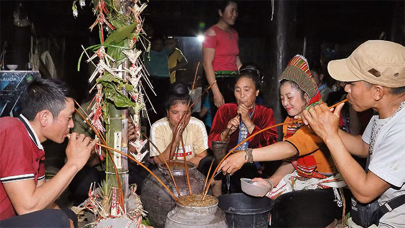 Người dân tham gia lễ “Mượng ma” cùng nhau vít rượu cần. Người dân tham gia lễ “Mượng ma” cùng nhau vít rượu cần.