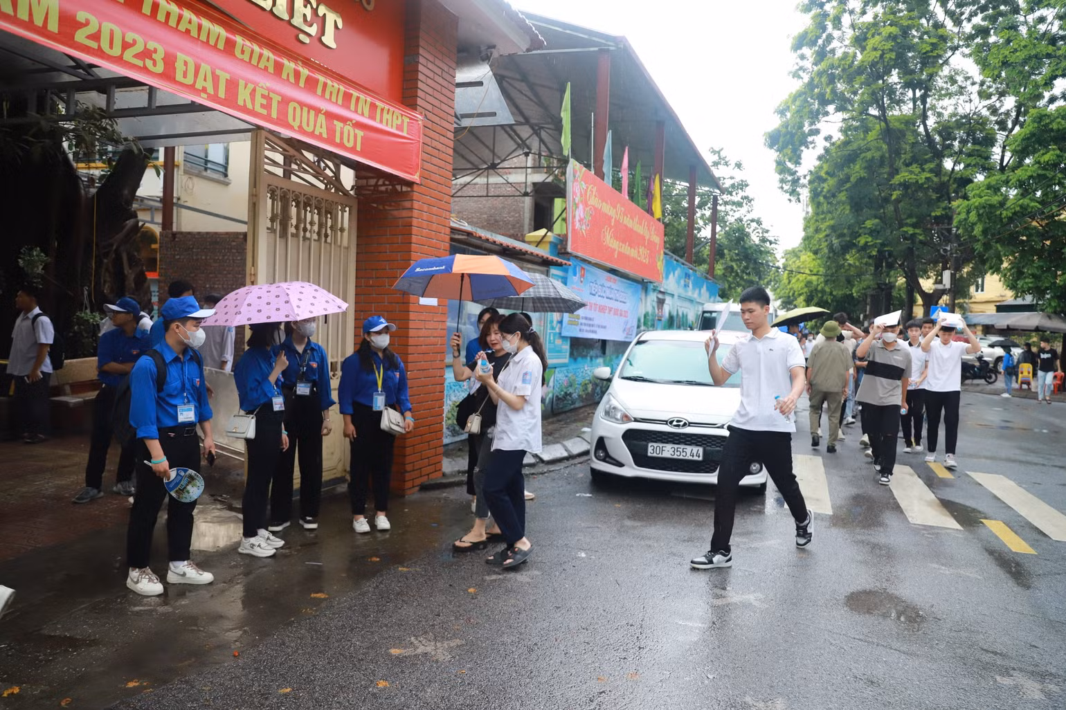 Cơn mưa đầu buổi sáng khiến các thí sinh gặp đôi chút trở ngại. Tại điểm thi Trường trung học cơ sở Hoàng Liệt (Hoàng Mai, Hà Nội), ngay từ hơn 6 giờ sáng, các thí sinh đã có mặt để chuẩn bị "vượt vũ môn". (Ảnh: Sơn Bách)